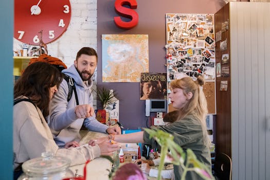 Guests checking in at a hostel reception with a warm interaction between a couple and staff.