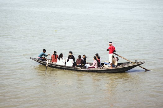 A group of people traveling across a calm river in a traditional wooden boat.