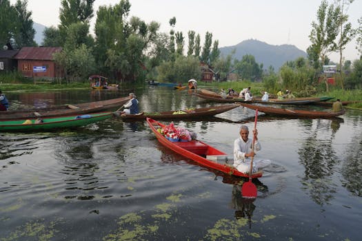 Men rowing boats filled with flowers on a tranquil river surrounded by lush greenery.