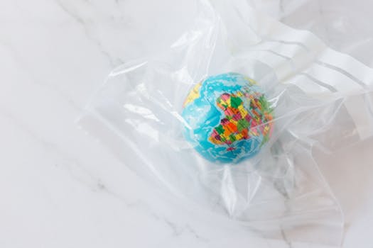 Mini globe encased in a plastic bag symbolizing environmental concerns about plastic waste.